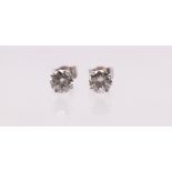 A pair of diamond and 18ct white gold solitaire stud earrings, comprising claw set  round