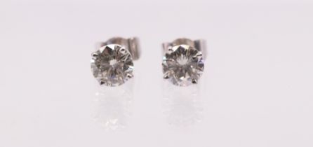 A pair of diamond and 18ct white gold solitaire stud earrings, comprising claw set  round