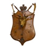 Taxidermy: an adult Red Deer Stag's head mounted on carved oak shield shaped wall mount surmounted