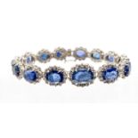 A sapphire and diamond white gold cluster bracelet, comprising a row of graduated oval mixed cut