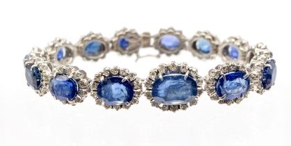 A sapphire and diamond white gold cluster bracelet, comprising a row of graduated oval mixed cut