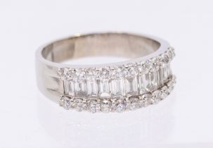 A diamond and 18ct white gold ring, comprising a central channel set row of eleven tapering baguette