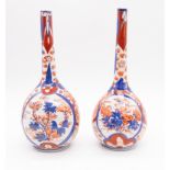 A pair of Japanese Imari pattern onion shaped bottles, decorated with panels of flowers, circa 1900,