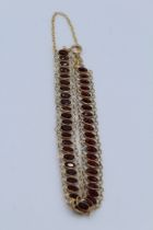 A 9ct gold and garnet link bracelet, rub over set row of oval cut garnets, 6.0gm
