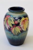 A Moorcroft Leaf and Berry pattern vase of ovoid shape, brightly coloured on a shaded blue/ green