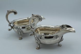 John Jacob, a pair of crested George II silver sauce boats, each with leaf capped scroll handle,