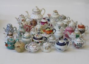 A collection of several dozen largely 20th century teapots including collector's pieces, souvenir