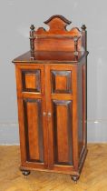 An Edwardian rosewood upright collectors cabinet, the near full length pair of panel doors enclosing