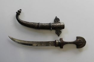 A late 19th/ early 20th century Jambiya, the carved wood gilt metal mounted grip above a 23cm double
