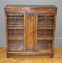 An early 20th mahogany bookcase, having a pair of glazed doors enclosing adjustable shelves, on