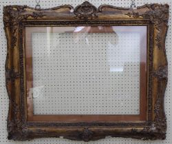 A Victorian giltwood and gesso portrait picture frame, with scallop and trailing bell flower