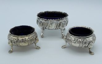 A pair of Edwardian silver repousse decorated bun form salts, Birmingham 1909, together with