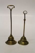 Two Victorian brass door porters, each with loaded half-bell form base. 42cm (tallest)