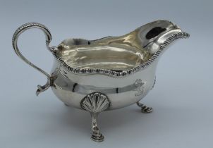 William Skeen, a George III silver sauce boat with reeded scroll handle and gadrooned rim, raised on