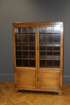 An early 20th century oak bookcase with glazed doors and cupboards, adjustable shelves, on bracket