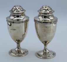William Comyns, a pair of Edwardian silver sugar casters, each of pedestal urn form, on stepped