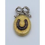 An Edwardian 18ct gold locket with blue enamel and diamond horseshoe detail, suspended from a