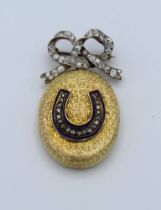 An Edwardian 18ct gold locket with blue enamel and diamond horseshoe detail, suspended from a