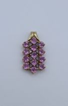 A 9ct gold, pinkish purple sapphire and diamond pendant featuring 13 round mixed cut sapphires and