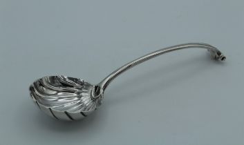 A George III silver sauce ladle with scallop bowl and scroll terminal. London marks rubbed, 17cm