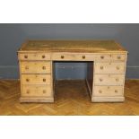 An Edwardian oak kneehole pedestal desk, the oblong top with tooled inset leather panel over one