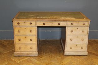 An Edwardian oak kneehole pedestal desk, the oblong top with tooled inset leather panel over one