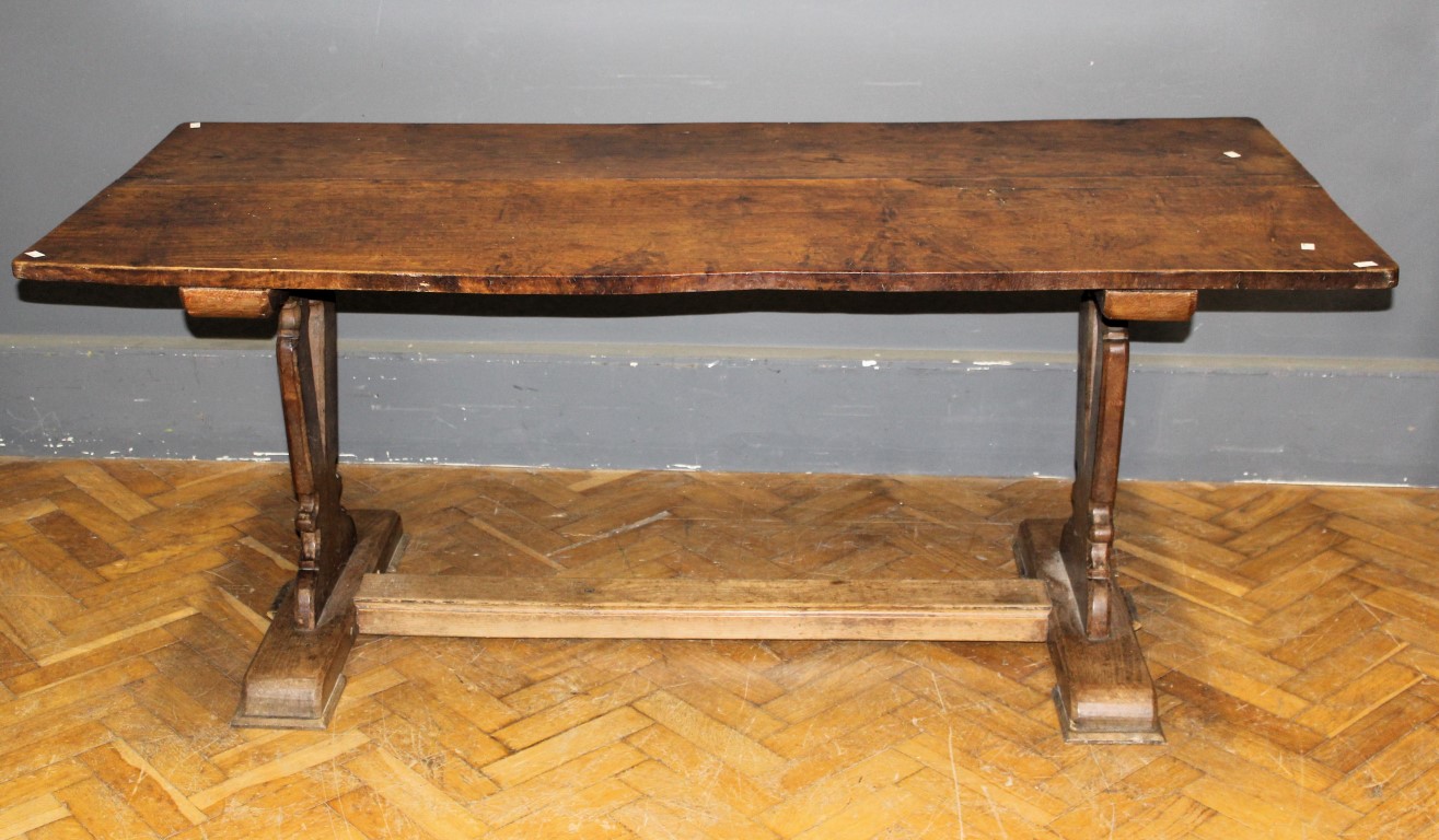 A Victorian oak refectory dining table, the rectangular planked top on pierced end supports and