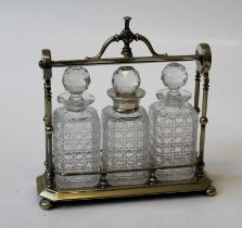 A silver plated tantalus, having three cut glass decanters and stopper, one with silver collar,