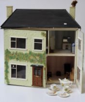 A circa 1940's dolls house containing various furniture and effects of the period and later , a