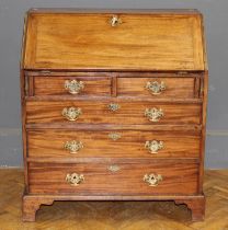 A George III mahogany bureau with fitted fall over two short and three long drawers, on bracket