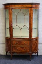 An Edwardian Sheraton-Revival, satinwood, crossbanded and ebony strung break bowfront vitrine. The