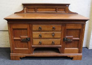 An Edwardian oak sideboard, the ledgeback over three central drawers flanked by a pair of panel