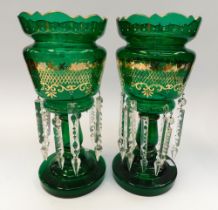 A pair of late Victorian green glass garnitures with gilt detail and glass droplets.