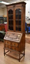 An early 20th century oak bureau bookcase in the Jacobean style, with glazed front book case