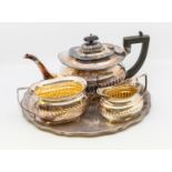 An early 20th century silver plated three piece tea set with plated tray, gilt to insides.