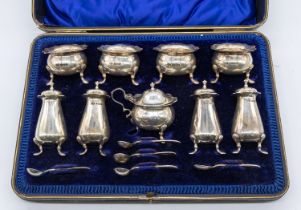 An Edwardian silver condiment set consisting of four salts, four pepper pots, one mustard pot,