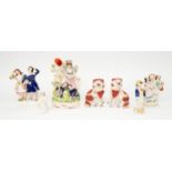 Seven Staffordshire figurines to include; A lady with two children posy holder, a couple hand in