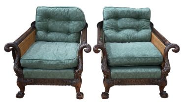 A pair of bergere armchairs, having ornate carved detail of eagle-headed arms, and foliate detail,