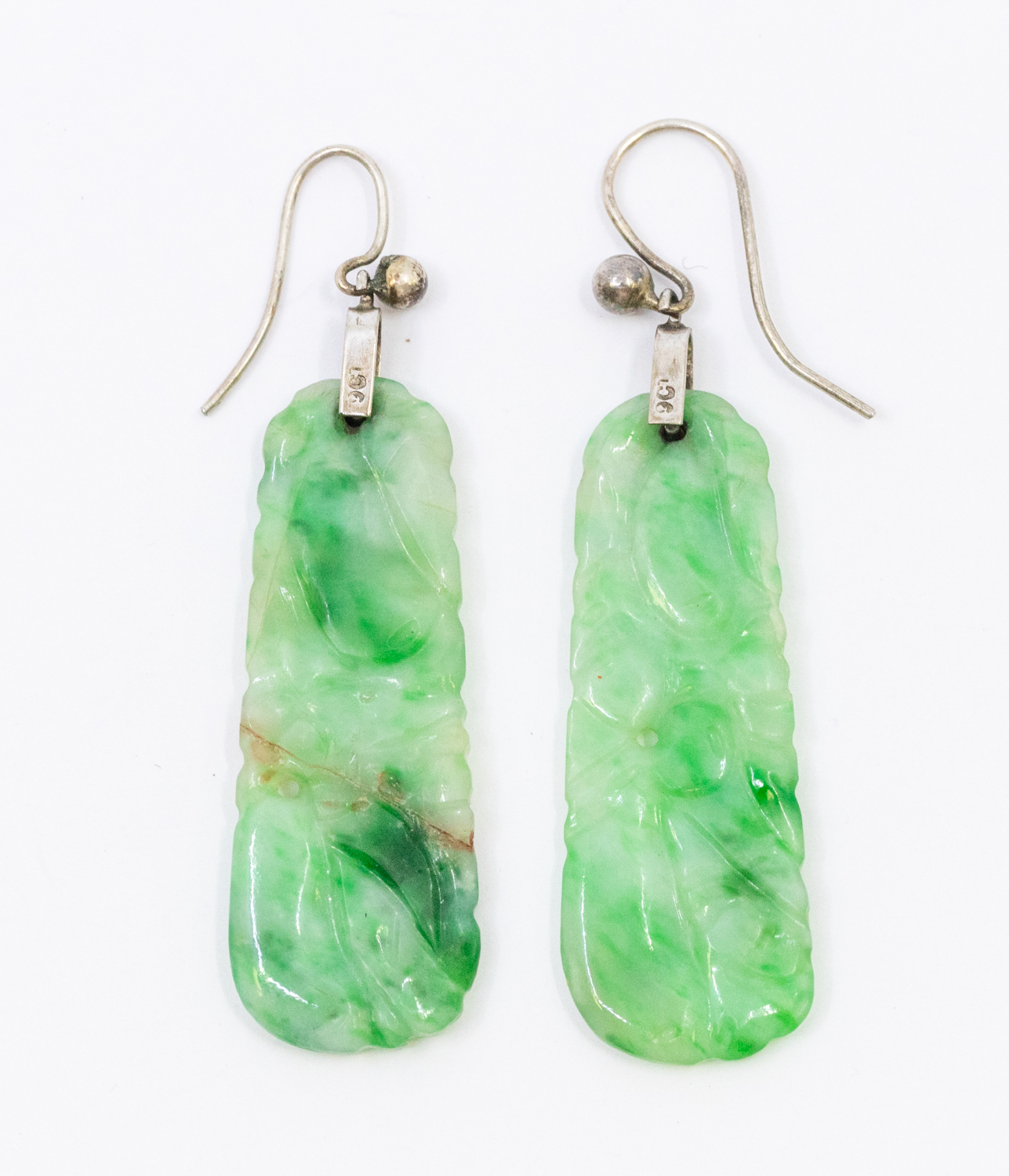 A pair of jade and 9ct white gold crop earrings, comprising a carved jade drop on hook fittings,
