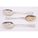 Three George III silver berry spoons to include; a Newcastle hallmarked with elaborate engraved