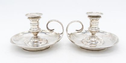 A pair of late Victorian silver chambersticks, swirl handled and detachable sconces, both with