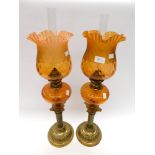 Pair of late Victorian brass stemmed oil lamps with glass oil compartment with matching orange