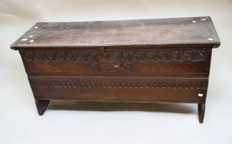 A mid-17th century dark oak coffer, made from single timbers, carving to front, single timber