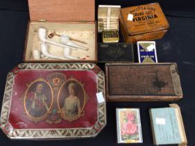 A collection of 19th century clay pipes, vintage tins and vintage playing cards.