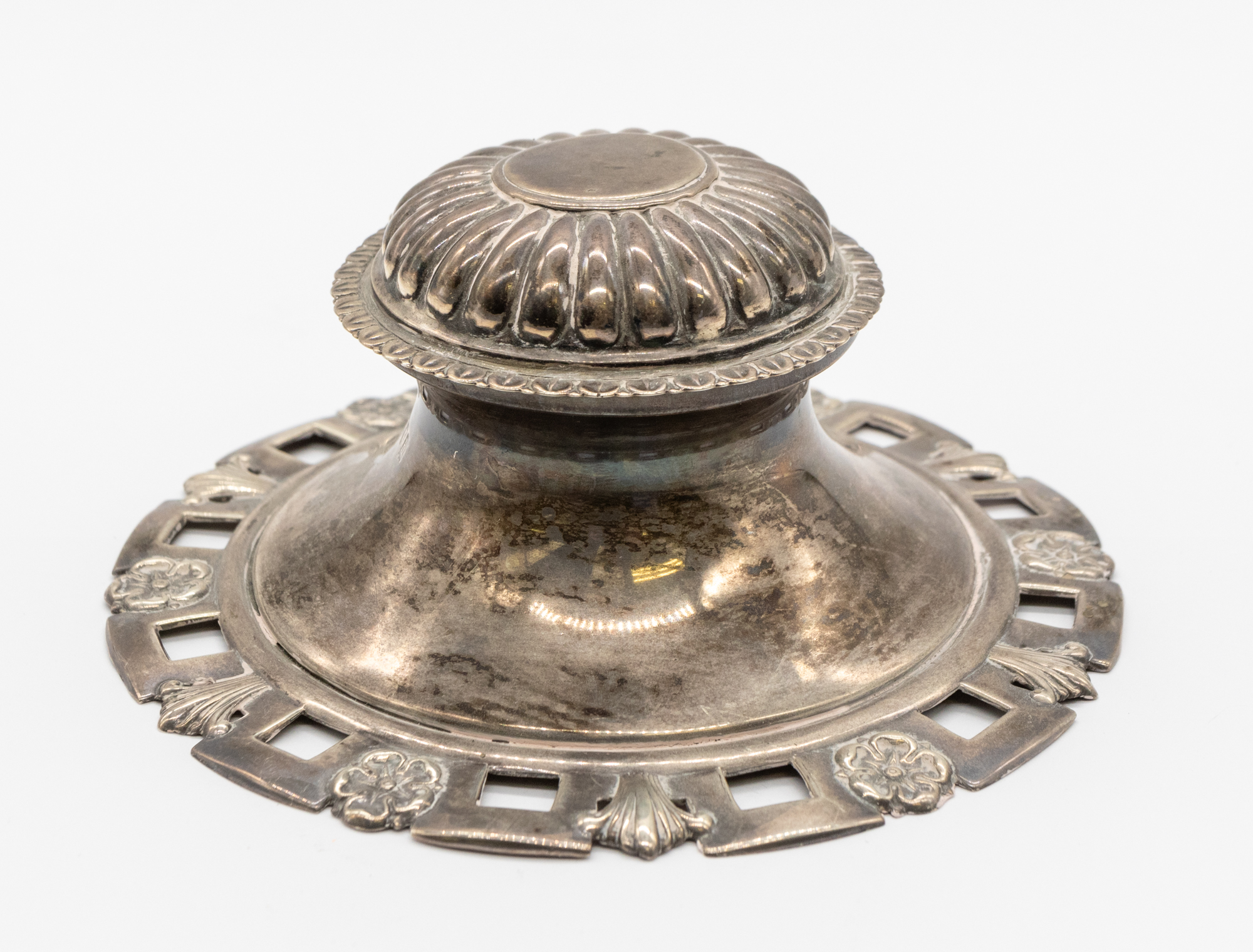 An early 20th century Edwardian silver capstan inkwell, having a stylised pierced design with rose