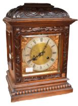 A 20th century bracket clock with presentation plaque to top, with carved detail to wooden casing.