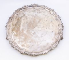 A large late Victorian silver salver, having ornate scalloped edging, three ball and claw feet and