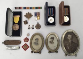 A selection of military related badges, medals, photographs and religious badges. To include: a