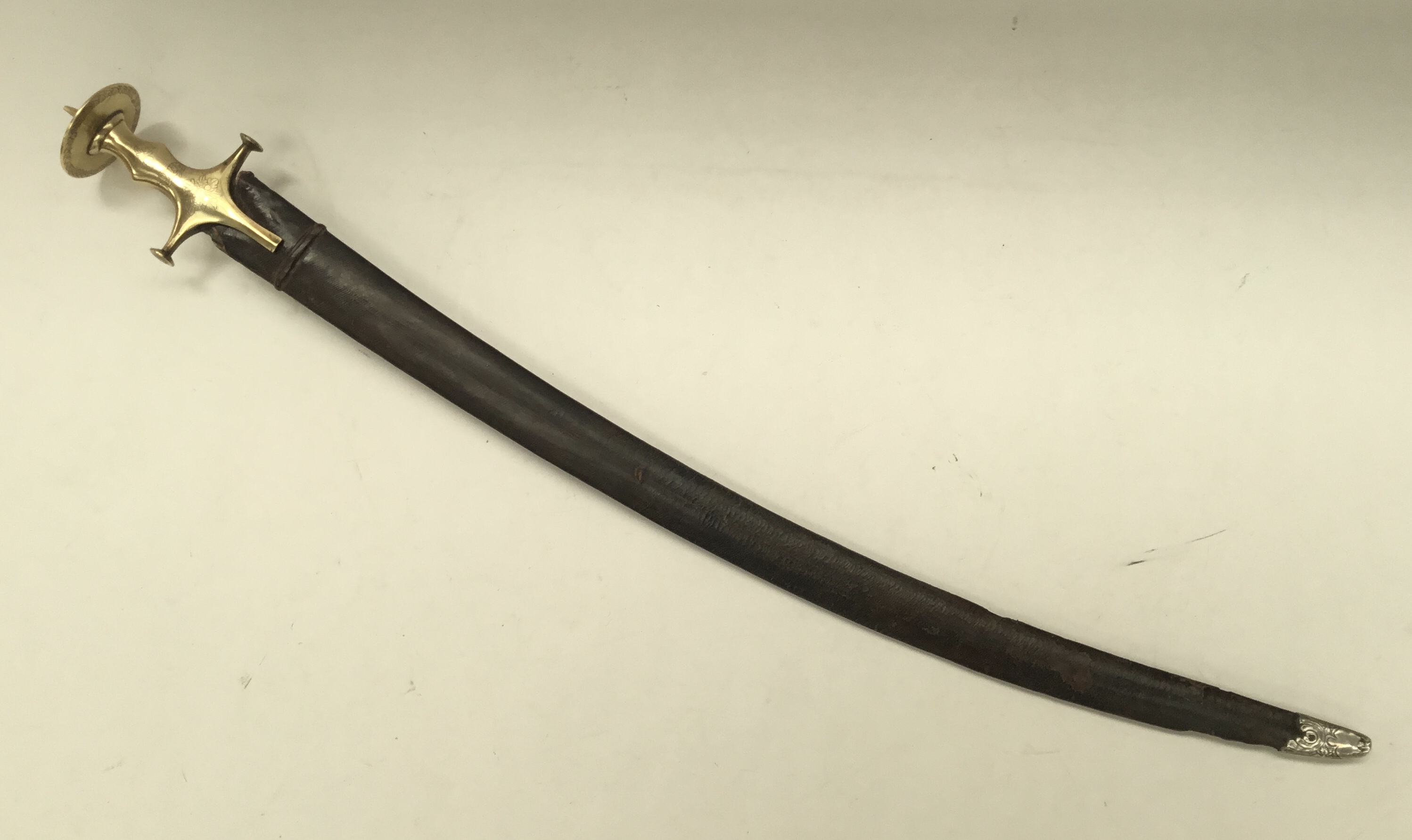 A 19th century Indian talwar sword. Typical form, with brass handle, convex quillons, and disc