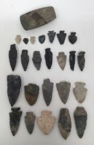 A collection of 24 ancient Native American flint arrow heads, spear heads, and an axe head.